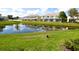 Beautiful pond view with lush green lawn and nearby neighborhood buildings at 1523 Still Dr, Clermont, FL 34714
