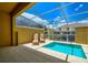 Private screened-in pool with lounge chairs and sunny sky above at 1523 Still Dr, Clermont, FL 34714