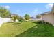 Spacious backyard with a lush lawn, a white fence, and mature landscaping at 1703 Leatherback Ln, St Cloud, FL 34771