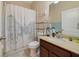 Bathroom featuring a shower/tub combo, a tan vanity, and a Parisian themed shower curtain at 1703 Leatherback Ln, St Cloud, FL 34771