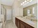 Bright bathroom with double sinks, tile flooring, and a glass enclosed shower at 1703 Leatherback Ln, St Cloud, FL 34771