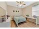 Well-lit bedroom with light wood floors, a desk, and ample natural light from a window at 1703 Leatherback Ln, St Cloud, FL 34771