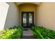 Elegant entryway with double doors and lush greenery creating a welcoming entrance at 1703 Leatherback Ln, St Cloud, FL 34771