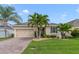 Charming single-story home featuring a brick driveway, lush landscaping, and a two-car garage at 1703 Leatherback Ln, St Cloud, FL 34771