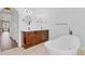 Bathroom with double vanity, soaking tub, and tile flooring with hallway views at 1705 Ridgemoor Dr, Mascotte, FL 34753