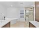 Luxurious bathroom featuring a soaking tub, frameless shower, and double vanity sinks at 1705 Ridgemoor Dr, Mascotte, FL 34753