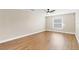 Bedroom with wood-look floors, window, ceiling fan and neutral colored walls at 1705 Ridgemoor Dr, Mascotte, FL 34753