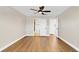 Bright bedroom features wood-look flooring, ceiling fan, and ensuite bathroom at 1705 Ridgemoor Dr, Mascotte, FL 34753