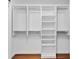 Walk in closet with custom white shelving and organizers and wood-look flooring at 1705 Ridgemoor Dr, Mascotte, FL 34753
