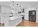 Modern kitchen with white cabinets, a sleek island, stainless steel appliances, and stylish pendant lights at 1705 Ridgemoor Dr, Mascotte, FL 34753
