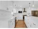 Elegant kitchen with white cabinets, black hardware, and stainless steel appliances at 1705 Ridgemoor Dr, Mascotte, FL 34753