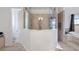 Elegant primary bathroom featuring glass-enclosed shower, tile surround, and spa tub with backyard views at 17117 Heartwood Loop, Winter Garden, FL 34787