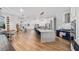 Open concept layout showcasing kitchen island, stainless appliances, with living and dining areas with wood floors at 17117 Heartwood Loop, Winter Garden, FL 34787