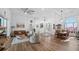 Inviting living room featuring hardwood floors, comfortable seating, and an open layout connecting dining and entrance at 17117 Heartwood Loop, Winter Garden, FL 34787