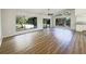 Bright living room with wood floors, a ceiling fan, and large windows showcasing the outdoor view at 1738 Athens Ct, Lakeland, FL 33803