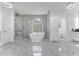 Bright and open bathroom with marble flooring, a freestanding tub, walk-in shower, and vanity at 1943 Wingfield Dr, Longwood, FL 32779
