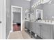 This bathroom features dual sinks with gray cabinetry and a large mirror at 1943 Wingfield Dr, Longwood, FL 32779