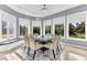 Dining room with bay windows, modern chandelier, views of the outdoors, and an accent rug at 1943 Wingfield Dr, Longwood, FL 32779