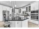 Bright kitchen featuring white cabinetry, black countertops, mosaic backsplash, and stainless steel appliances at 1943 Wingfield Dr, Longwood, FL 32779