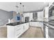 Modern kitchen with white cabinetry, stainless appliances, and black countertop island at 1943 Wingfield Dr, Longwood, FL 32779