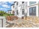 Covered stone patio with an outdoor table with chairs, lush landscaping, and a stately home at 1943 Wingfield Dr, Longwood, FL 32779