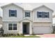 Charming two-story home with gray stone accents, a two-car garage, and a neatly landscaped front yard at 1988 Iorio Dr, St Cloud, FL 34771