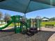 Community playground with a green play structure and sunshade, providing a fun and safe play area at 2036 Iorio Dr, St Cloud, FL 34771
