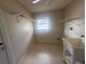 Practical laundry area with a large utility sink and tile flooring, with shelving for supplies at 204 W Cottesmore Cir, Longwood, FL 32779
