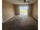 Open living room with carpet flooring and sliding glass doors leading to a fenced backyard at 204 W Cottesmore Cir, Longwood, FL 32779