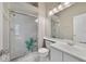 Bright bathroom features a glass-enclosed shower, toilet, vanity, mirror, and light fixtures at 2808 Osprey Cove Pl # 202, Kissimmee, FL 34746