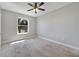 Bedroom with neutral paint, carpet, ceiling fan, and a large window showcasing the outdoor view at 2808 Osprey Cove Pl # 202, Kissimmee, FL 34746