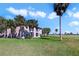 Exterior of this multi-Gathering home showing a manicured lawn and swaying palm trees at 2808 Osprey Cove Pl # 202, Kissimmee, FL 34746