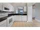 Updated kitchen with white cabinetry, stainless steel appliances, and an arched opening leading to another room at 2808 Osprey Cove Pl # 202, Kissimmee, FL 34746