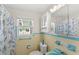 Well-lit bathroom features colorful seashell curtain, and coordinating vintage tile at 3226 S Peninsula Dr, Daytona Beach Shores, FL 32118