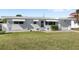 A well-maintained single-story home with white brick, awnings, and a manicured lawn at 3226 S Peninsula Dr, Daytona Beach Shores, FL 32118