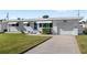 A charming single story home with a well-manicured lawn, white brick exterior, and a one-car garage at 3226 S Peninsula Dr, Daytona Beach Shores, FL 32118
