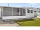 View of the home's exterior featuring a screened lanai and landscaped yard at 3226 S Peninsula Dr, Daytona Beach Shores, FL 32118
