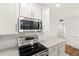 Modern kitchen with stainless steel appliances, white cabinets, and stone countertops at 3226 S Peninsula Dr, Daytona Beach Shores, FL 32118