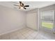 Neutral bedroom featuring tile floors, closet, and a large window at 33 Silver Oak Cir, Kissimmee, FL 34743