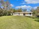 Backyard view showcasing the home's exterior, a well-maintained lawn, and a wooden deck at 4112 Grove Pl, Lakeland, FL 33810