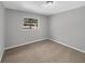 Cozy bedroom with a window providing natural light and neutral-toned walls and carpet at 4112 Grove Pl, Lakeland, FL 33810