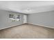 Neutral living room featuring a large window, natural light, and neutral colored walls and carpet at 4112 Grove Pl, Lakeland, FL 33810
