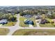 An aerial shot reveals the home's manicured lawn and paved driveway, nestled in a tranquil, green neighborhood at 4590 Sw 99Th St, Ocala, FL 34476