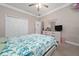 Well-lit bedroom with a ceiling fan, closet, and a dresser with a mirror and TV at 4590 Sw 99Th St, Ocala, FL 34476