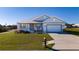 Well-maintained single-story home with a gray exterior, two-car garage, and manicured front lawn at 4590 Sw 99Th St, Ocala, FL 34476