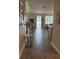 Long hallway with wood floors and a view of an open kitchen and dining area, allowing natural light to fill the space at 4590 Sw 99Th St, Ocala, FL 34476