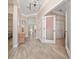 Inviting hallway featuring wood-look tile flooring, elegant lighting fixtures, and access to bedrooms at 4590 Sw 99Th St, Ocala, FL 34476