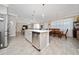 Open-concept kitchen with stainless appliances, central island, and connected dining and living spaces at 4590 Sw 99Th St, Ocala, FL 34476