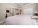 Spacious bedroom with soft lighting, crown molding, and frosted glass doors to the hallway at 4590 Sw 99Th St, Ocala, FL 34476