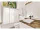 Bright bathroom featuring a single sink vanity, granite countertop and glass-enclosed shower at 4721 Tara View Road, Leesburg, FL 34748